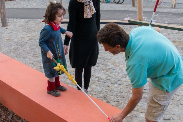 Ein Mädchen lernt den Umgang mit dem Blindenstock in der Stadt.