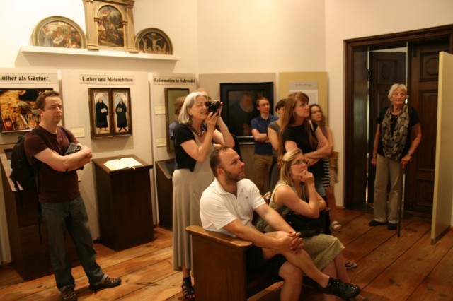 Künstler und Künstlerinnen besuchen ein Museum.